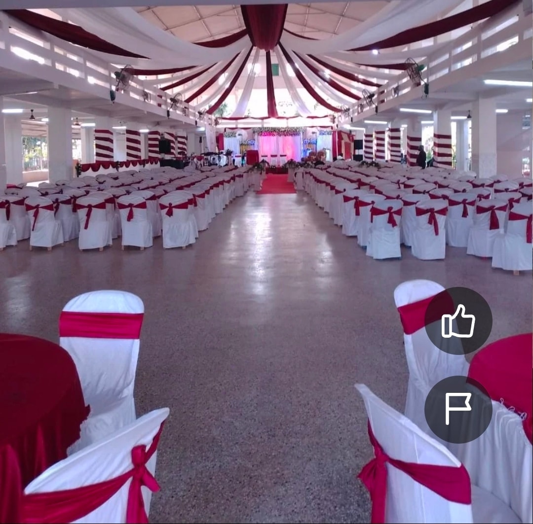 Grand 1,500-seat wedding convention centre banquet hall at Kalathur Gardens with maroon and white chair covers