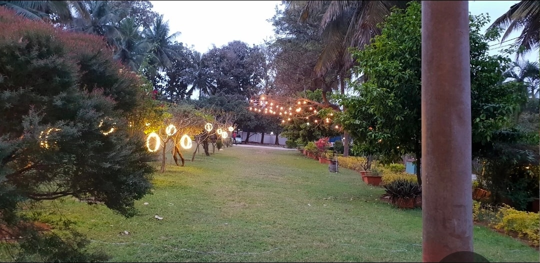 Garden resort lawns with warm string lights at Kalathur Gardens — outdoor wedding reception venue in Bangalore